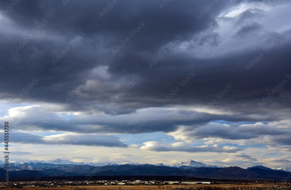 ominous afternoon storm clouds over long's peak and the front range of the colorado rocky mountains, as seen from broomfield, colorado