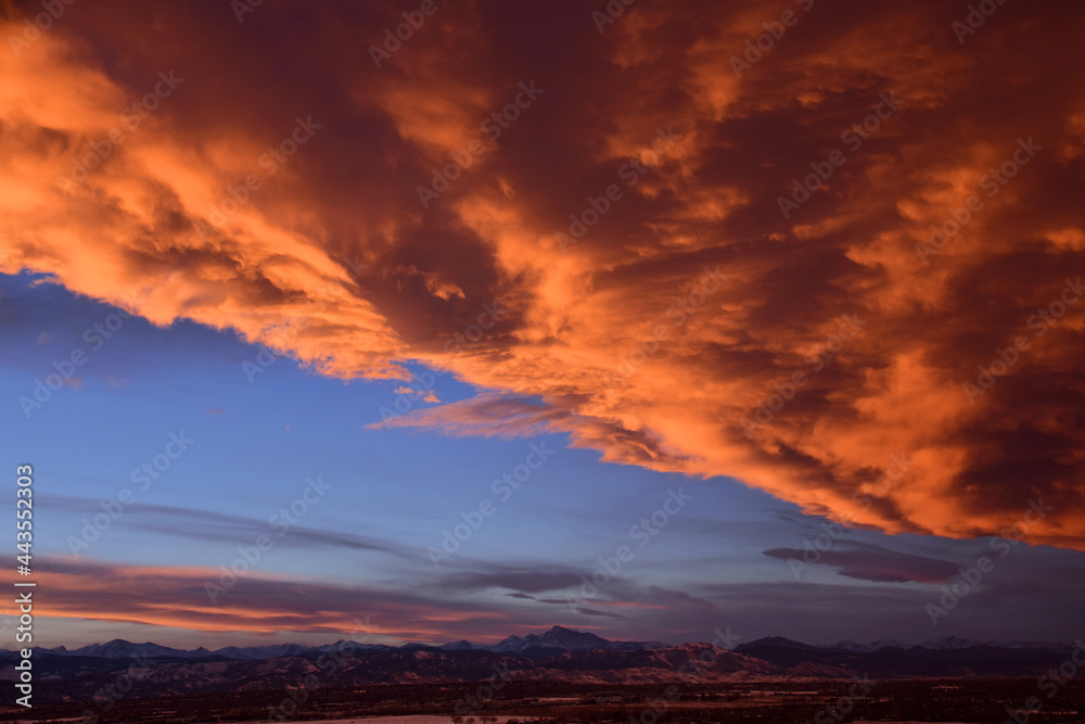 dramatic front of clouds moving in  across long's peak and the front range  at sunset, as seen from broomfield, colorado 