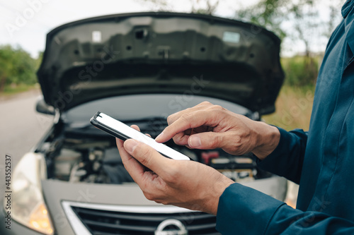 young man calling,  texting for car service on roadside assistance after broken car. Car broken, car breakdown concept.