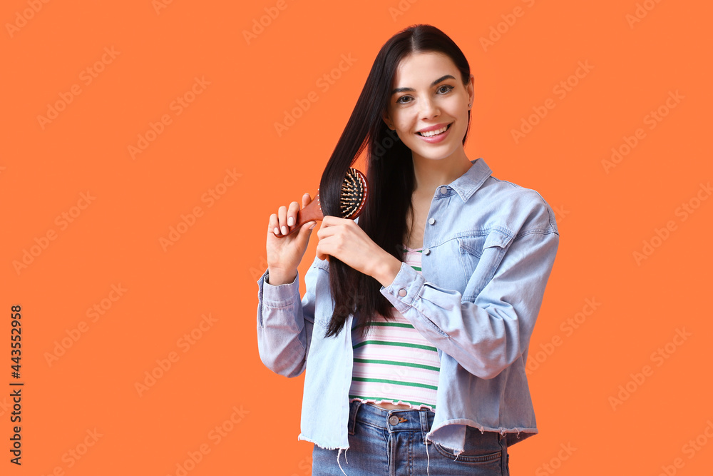 Beautiful young woman with hair brush on color background Beautiful young woman with hair brush on color background