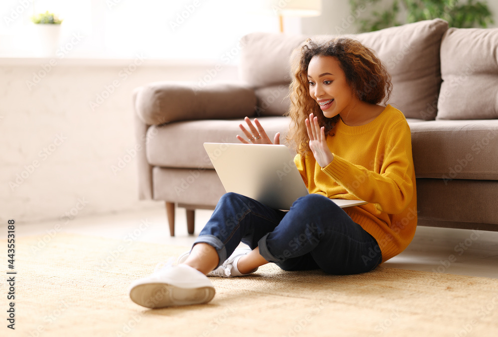 Surprised afro american woman having video call while working or studying online on sofa at home Surprised afro american woman having video call while working or studying online on sofa at home