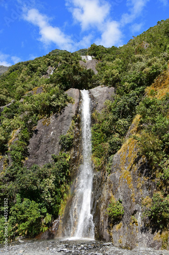 beautiful trident creek waterfalls on a sunny summer  along the franz joseph glacier  walk   near the town   of franz joseph on the west coast of the south island of new zealand