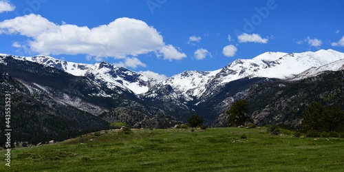 snow-capped mountain peaks and green meadow in spring in the moraine park area of rocky mountain national park, colorado