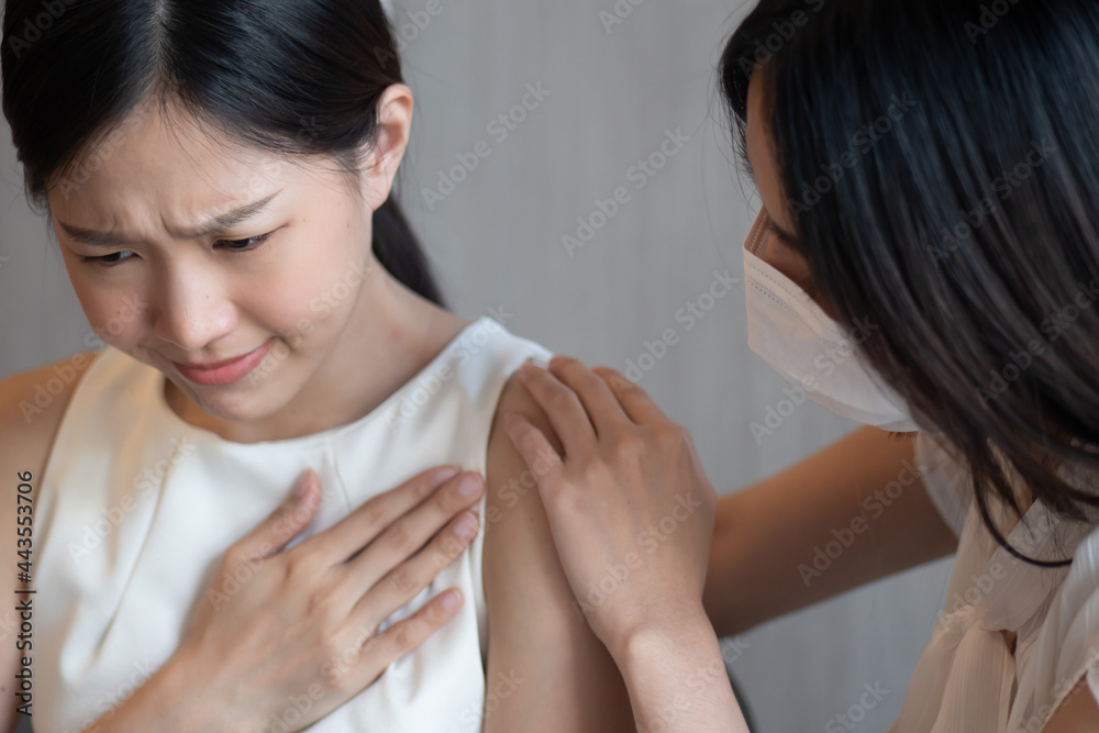 Vaccinated woman wearing face mask taking care of unvaccinated woman having pneumonia as symptomatic infection without wearing face mask, preventive covid-19 vaccine and precaution face mask concept Vaccinated woman wearing face mask taking care of unvaccinated woman having pneumonia as symptomatic infection without wearing face mask, preventive covid-19 vaccine and precaution face mask concept