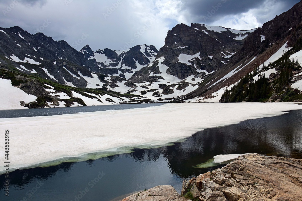 partially frozen  lake isabelle and spectacular mountain backdrop in summer, in the indian peaks wilderness area in the rocky mountains of colorado   