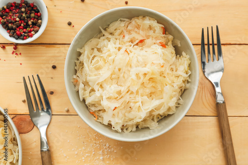 Bowls with tasty sauerkraut on wooden background