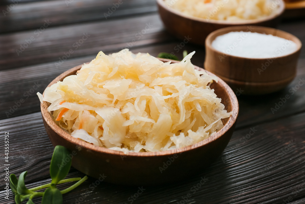 Bowl with tasty sauerkraut on dark wooden background Bowl with tasty sauerkraut on dark wooden background