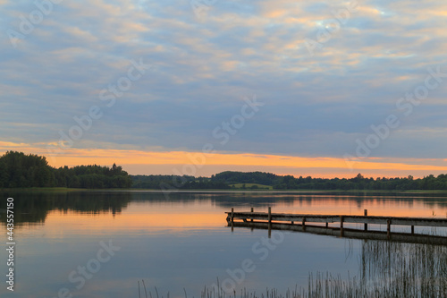 The lake and an old wooden footbridge enter it. Outdoor evening, sunset © Armands photography