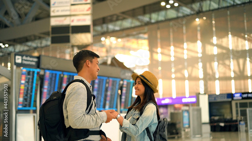 Couple Asian people walking in airport terminal waiting for  flight boarding to travel by air © Pixza