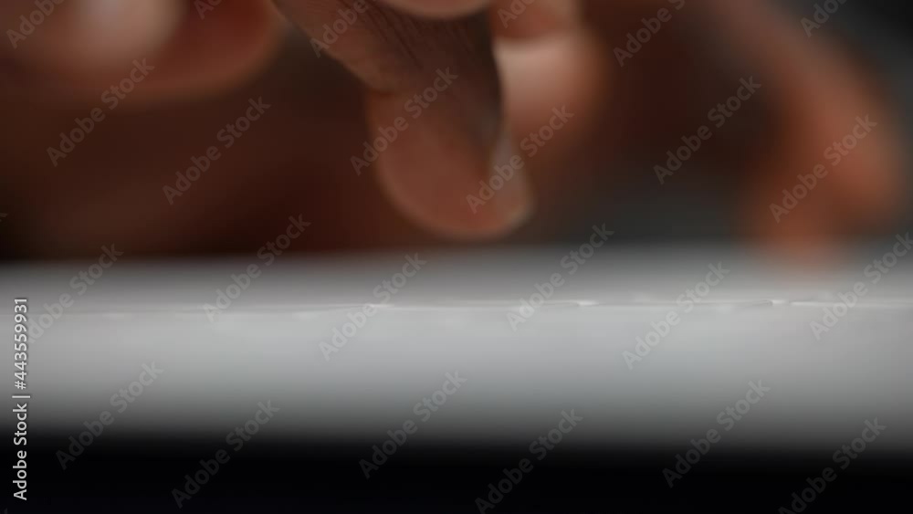 Super macro closeup shot of black African-American man's fingers typing on a white computer keyboard. Work, study. 