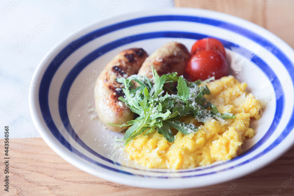 Risotto with pork sausages with cherry tomatoes and parsley on a plate. Italian cuisine concept