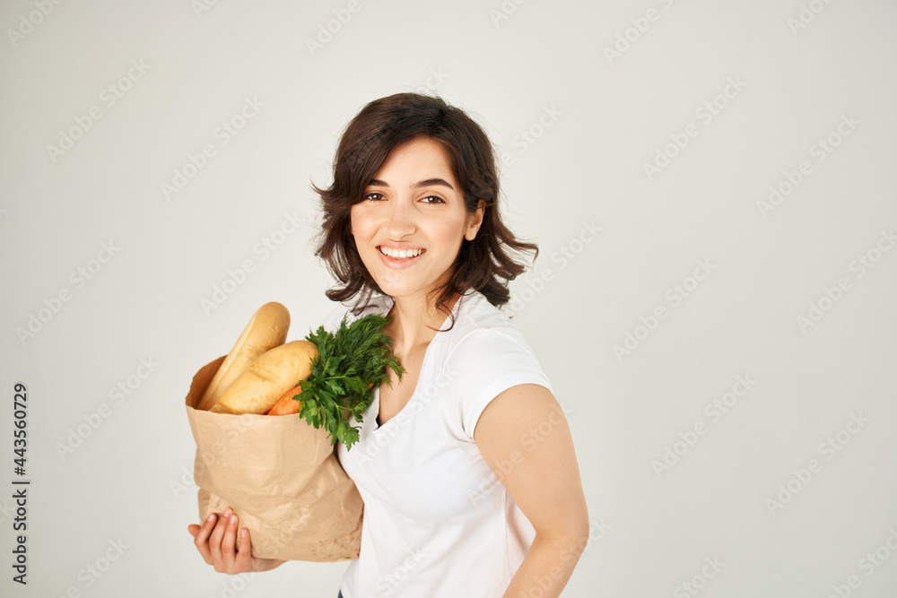 brunette with a package of groceries vegetables delivery