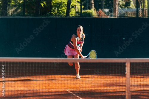 Professional equipped female tennis player serving the tennis ball on a sunny day