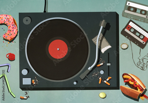Junk food, cigarettes and cassette tapes around record turntable
 photo