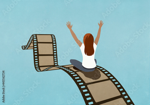 Excited woman riding movie film reel
 photo