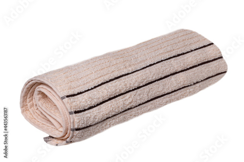 Towels isolated. Closeup of a rolled up beige soft terry bath towel isolated on a white background.