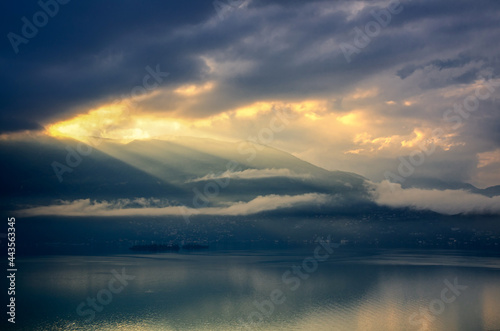 Storm Clouds with Sunlight over Brissago Islands on Alpine Lake Maggiore with Mountain in Ticino  Switzerland.