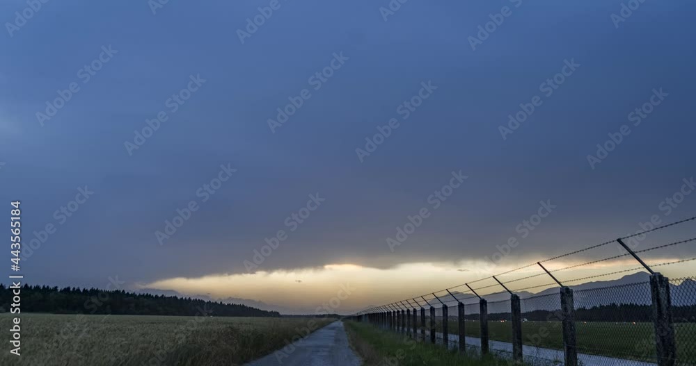 Time lapse of storm clouds forming in the evening. Slovenia international airport fence. Gravel or dirt road close to agricultural fields. Static shot, wide angle Time lapse of storm clouds forming in the evening. Slovenia international airport fence. Gravel or dirt road close to agricultural fields. Static shot, wide angle