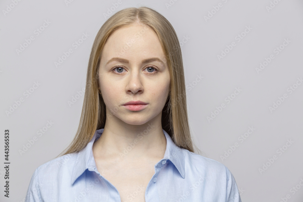 Portrait serious young woman against gray background
Portrait serious young woman against gray background