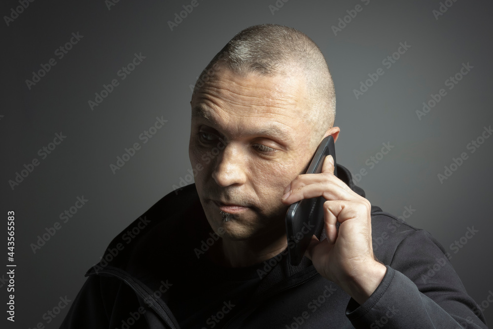 Mature man talking on smart phone against black background
Mature man talking on smart phone against black background