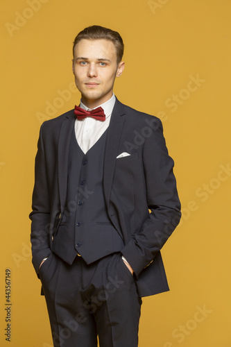 Studio portrait handsome young man in three piece suit with bow tie
 photo