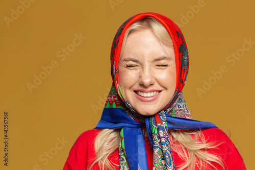 Portrait carefree woman in colorful babushka headscarf
 photo