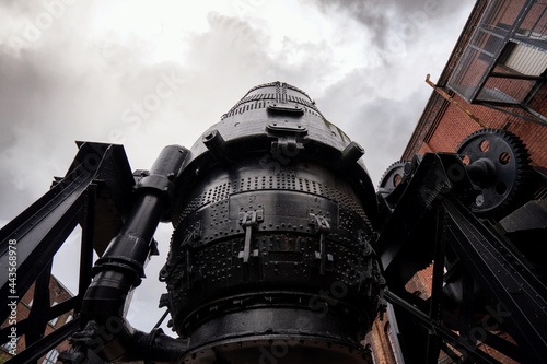 Bessemer converter steel and iron foundry equipment Sheffield bulk metal production. stormy cloud and large black gears and cogs.