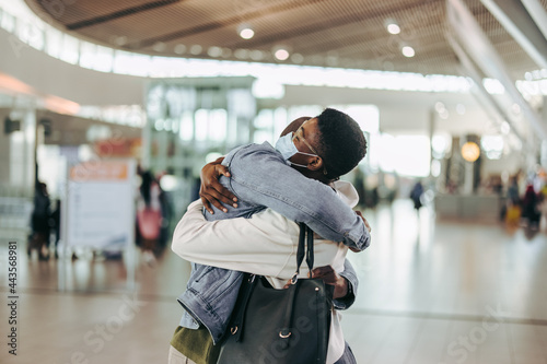Woman getting warm welcome hug from man at airport