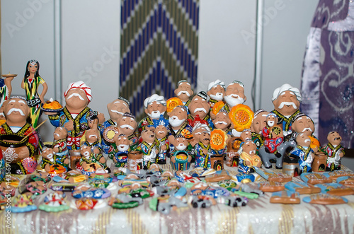 Traditional ceramic figurines of happy Uzbek men in national clothes with bread in hands