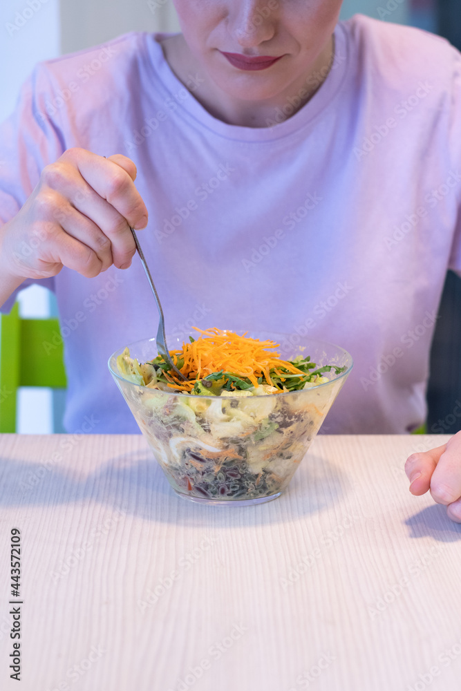Healthy eating, dieting and people concept - close up of young woman eating vegetable mixed salad in restaurant, in dining table. Woman eating fresh salad Healthy eating, dieting and people concept - close up of young woman eating vegetable mixed salad in restaurant, in dining table. Woman eating fresh salad
