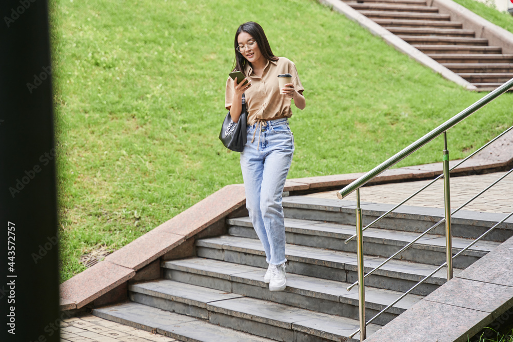 Woman recording voice message to somebody and drinking her coffee to go