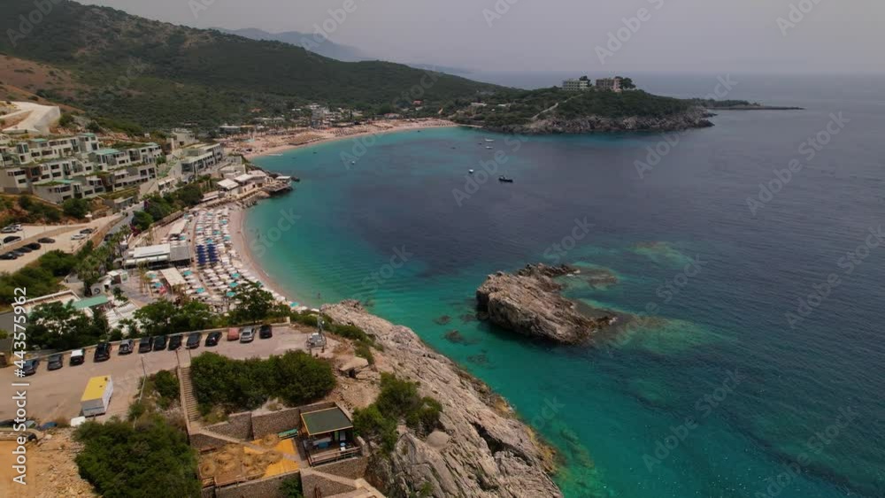 Beautiful bay with resorts on sandy beach surrounded by rocks and hills, emerald sea water in Jal, Albania Beautiful bay with resorts on sandy beach surrounded by rocks and hills, emerald sea water in Jal, Albania
