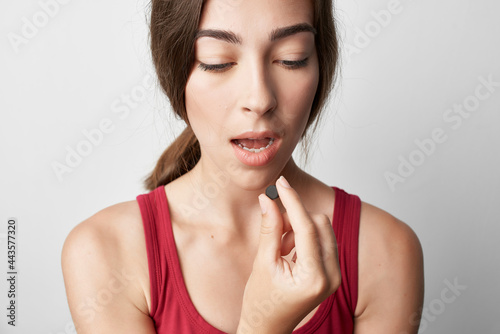 woman drinking pills with a glass of water health problems therapy