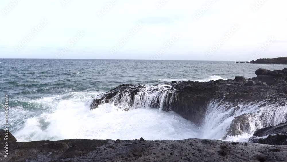 The ocean waves breaking on the rocks along the seashore casting spray into the air. The ocean waves breaking on the rocks along the seashore casting spray into the air.