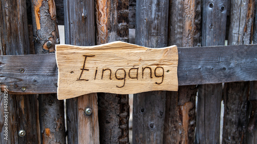 Eingang: Holzschild an einem Holzgatter photo