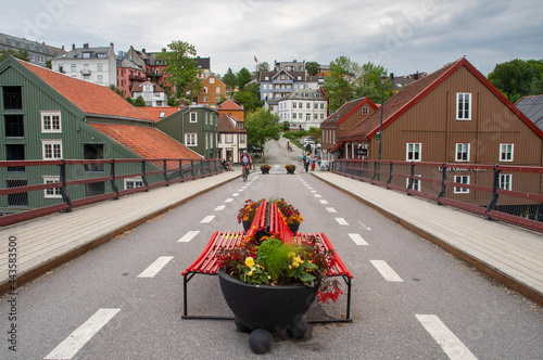 Gamle bybro, Trondheim, Norway. View from the old bridge with red benches and flower decorations. The famous Bakklandet in the background.