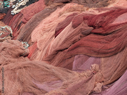 Des filets de pêche dans un camaïeu de rouges sèchent au soleil du Portugal 