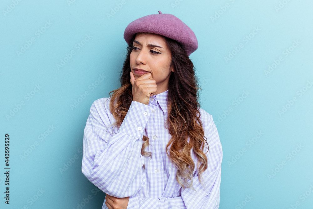 Young mexican woman isolated on blue background looking sideways with doubtful and skeptical expression. Young mexican woman isolated on blue background looking sideways with doubtful and skeptical expression.