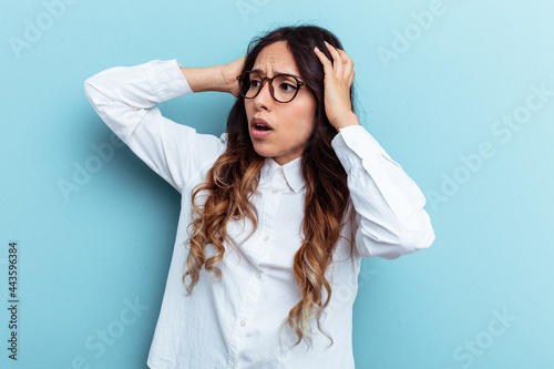 Young mexican woman isolated on blue background screaming, very excited, passionate, satisfied with something.