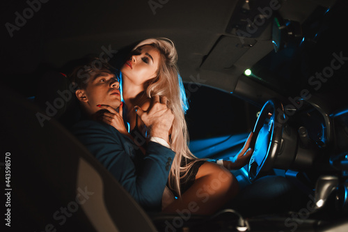 Couple kissing at night in the car. Gentle night photo session in the city. Summer vacation for lovers.