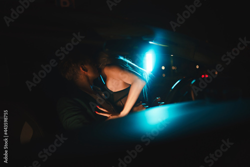 Couple kissing at night in the car. Gentle night photo session in the city. Summer vacation for lovers.