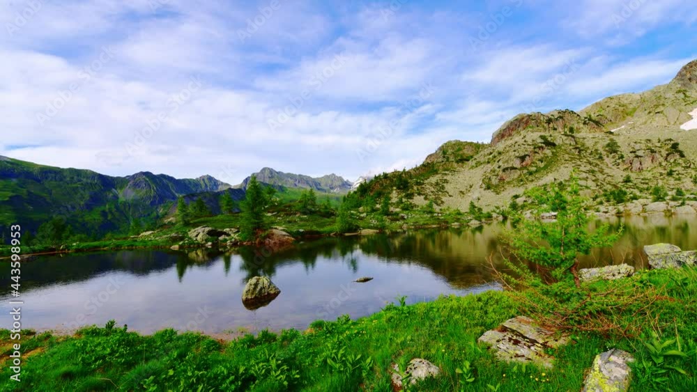 Time-lapse of alpine landscape with reflections in a lake Time-lapse of alpine landscape with reflections in a lake