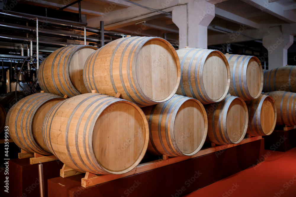 Old aged traditional wooden barrels with wine in a vault lined up in cool and dark cellar in Italy, Porto, Portugal, France Old aged traditional wooden barrels with wine in a vault lined up in cool and dark cellar in Italy, Porto, Portugal, France