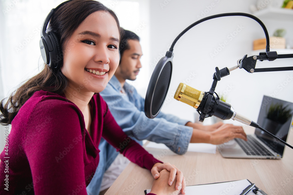 Asian female and male podcaster making audio podcast in home studio Asian female and male podcaster making audio podcast in home studio