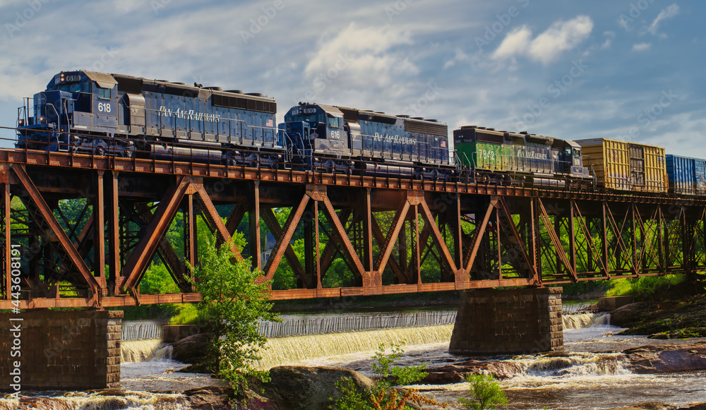 Pan Am Railways freight train engines crossing over a river on railroad