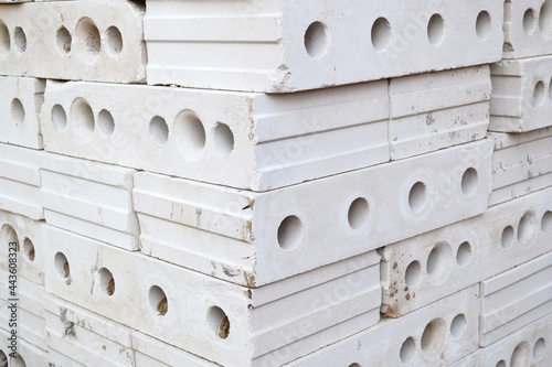 Gypsum hollow pazogrebnevye plates for partitions or internal walls are stacked in a pile on a construction site. Construction materials.Bricks