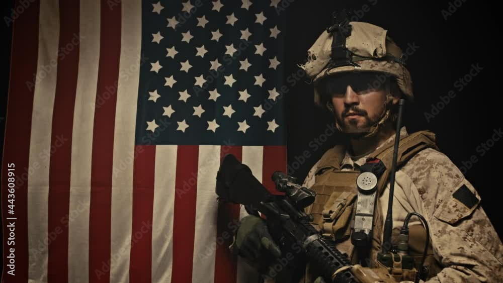 A soldier stands near the US flag. Patriotism. A soldier stands near the US flag. Patriotism.