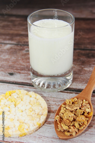 kefir in a glass and muesli in a spoon for a diet