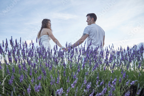 Photos of a man and a woman in the lavender fields. They're looking into each other's eyes while holding hands