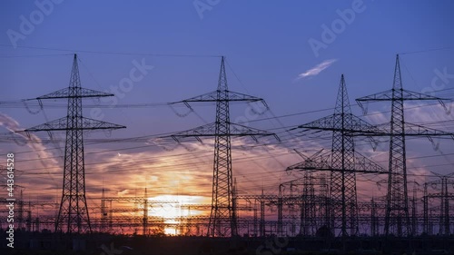sunset and orange sky behind power poles